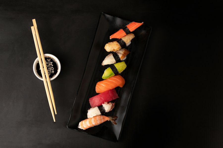 Nigiri selection on black stone with chopsticks